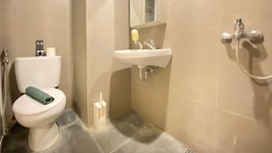 A small bathroom with a toilet, sink, and shower. - Comfy And Relax 1Br Apartment At Parahyangan Residence Near Unpar (Bandung)