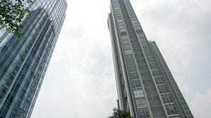 Deux immeubles de grande hauteur aux façades en verre réfléchissant.