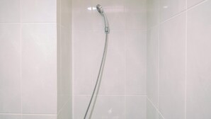 A shower with a handheld showerhead in a tiled bathroom. - Good Deal Studio At Evenciio Apartment Margonda Near Ui (Depok)
