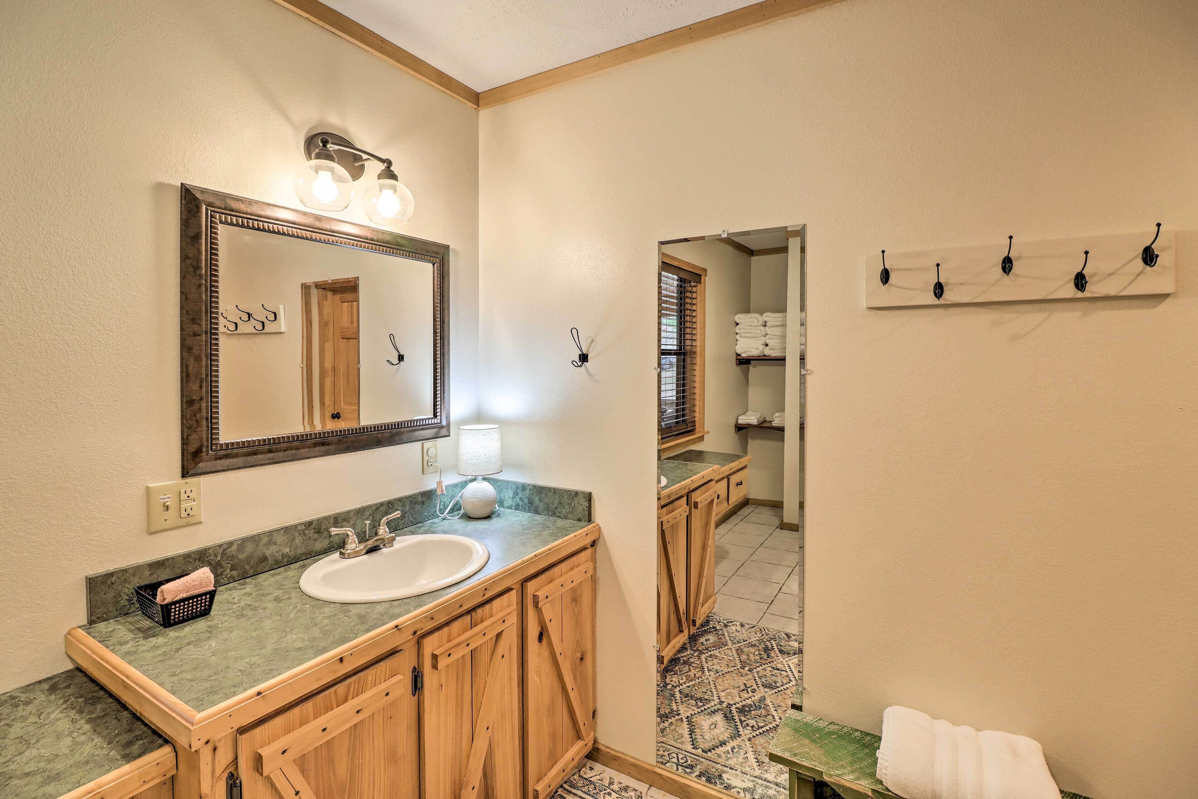Une salle de bain avec un meuble-lavabo en bois, un grand miroir et un porte-serviettes.