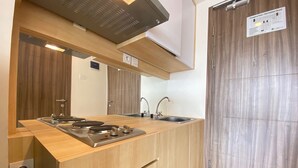 Una cocina moderna con armarios de madera, un lavamanos de acero inoxidable y una estufa empotrada.