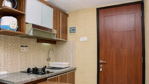 A compact kitchen with wooden cabinets, a built-in stove, and a sink. - Best Deal And Comfy 2Br At Kebagusan City Apartment (Jakarta)