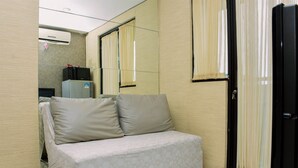 A small, furnished room with a sofa, a refrigerator, and a mirror. - Best Deal And Comfy 2Br At Kebagusan City Apartment (Jakarta)