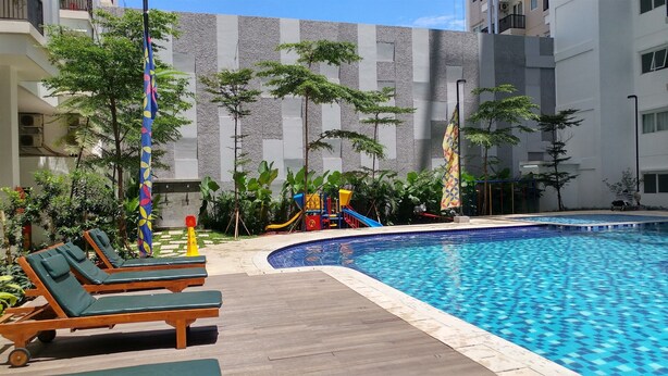 A swimming pool with lounge chairs and a children's play area.
