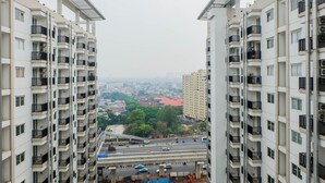 Ein Hochhaus mit mehreren Balkonen, Blick auf die Stadt und eine belebte Straße darunter.