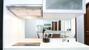 A modern kitchen with a white countertop, stainless steel appliances, and wooden cabinetry. - Modern 2Br At Signature Park Grande Apartment (Jakarta)