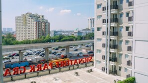 Un edificio alto con múltiples balcones y un estacionamiento al frente.
