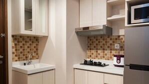 Una cocina con un lavamanos blanco, una estufa y un microondas.