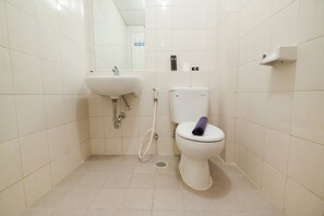 A small, clean bathroom with white tiles, a sink, a toilet, and a shower. - Great Location 1Br Signature Park Grande Apartment (Jakarta)