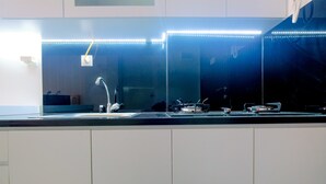 Een moderne keuken met een RVS spoelbak, een kraan en een aanrecht.