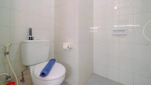 Een badkamer met een toilet, een handdoek en een toiletrolhouder.