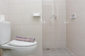 A bathroom with a toilet, a towel, and a shower area. - Comfy 2Br At Signature Park Grande Apartment (Jakarta)