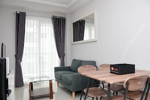 Relax in this stylish living room with a comfortable sofa, dining table, and flat-screen TV.