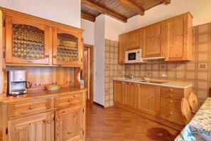 A kitchen with wooden cabinets, a microwave, and a coffee maker.
