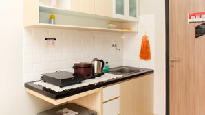 Uma cozinha com bancada, chaleira, cafeteira e pia.