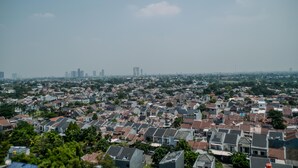 A residential area with houses and a distant city skyline. - Stunning And Comfy Studio Amazana Serpong Apartment (South Tangerang)