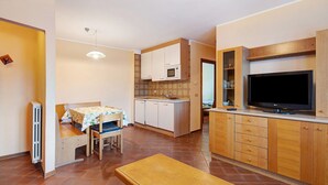 A compact kitchen with a dining area, a built-in microwave, and a flat-screen TV. - Apartment 'Chalet Meridiana 8' with Mountain View (Livigno)