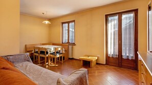 Une pièce comprenant un lit, une table à manger avec des chaises, un petit banc et un radiateur.