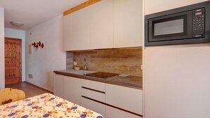 Une cuisine équipée d’un four à micro-ondes, d’un évier et d’un plan de travail en bois.