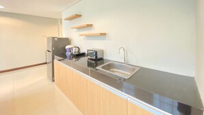 Eine moderne Küche mit Spüle aus Edelstahl, einer Kaffeemaschine und einem Toaster.