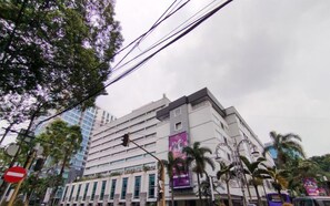 A multi-story building with a modern architectural design, featuring a prominent entrance and signage.