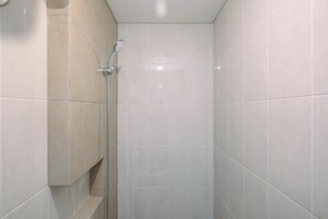 A tiled shower area with a handheld showerhead. - Nice And Elegant 1Br At Royal Heights Apartment (Bogor)