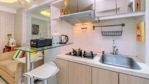 Une cuisine moderne dotée d’une table à plateau en verre, d’une cuisinière à gaz et d’un évier en acier inoxydable.