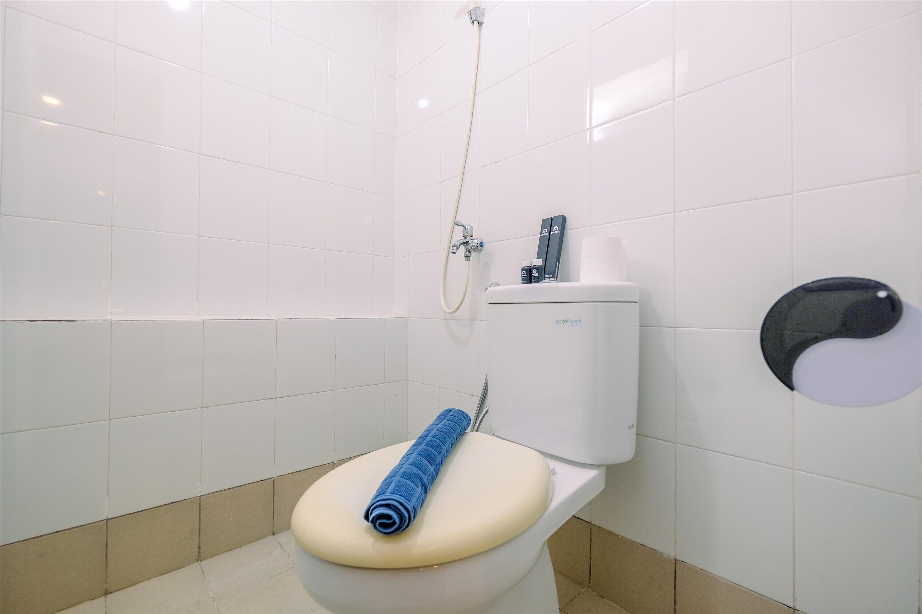 A bathroom with a toilet, a shower, and a hand dryer.