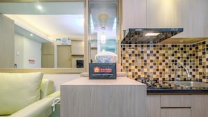 A modern kitchen with a built-in stove, a glass shelf, and a branded coffee machine. - Nice And Fresh 2Br At Bassura City Apartment (Jakarta)