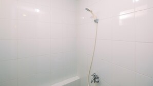 A small, white-tiled shower stall with a handheld showerhead and a wall-mounted faucet. - Nice And Fresh 2Br At Bassura City Apartment (Jakarta)