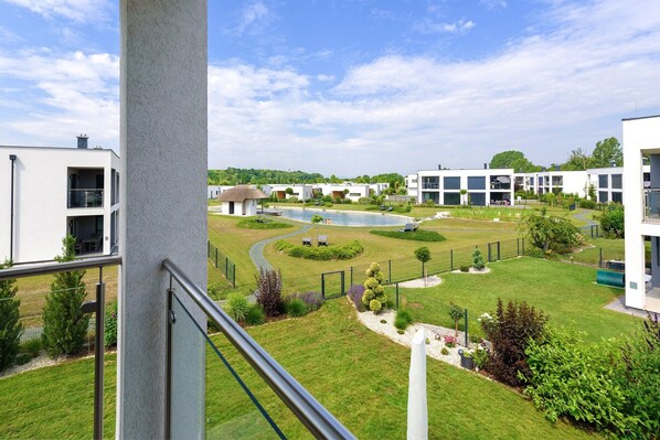 A residential area with modern buildings, a swimming pool, and well-maintained gardens.