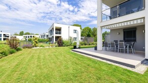 A modern residential area with multiple two-story houses, a well-maintained lawn, and outdoor seating area. - Heritage Apartment with Swimming Pond (Zsira)
