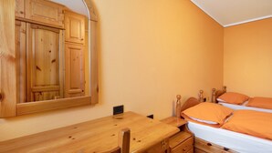 Une chambre avec un lit en bois, un bureau en bois et un grand miroir.