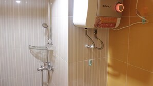 A bathroom with a glass shower enclosure, a handheld showerhead, a wall-mounted control panel, and a visible water outlet. - Cozy Studio Apartment At The Jarrdin Near Cihampelas Walk (Bandung)