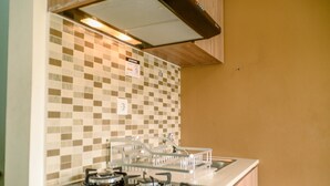 Una cocina con estufa a gas, un fregadero y un salpicadero de azulejos.