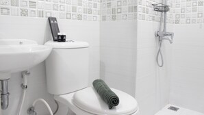 A bathroom with a toilet, sink, and shower. - Spacious And Modern Studio Room Apartment At Grand Asia Afrika (Bandung)