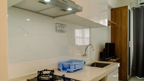 Una cocina moderna con estufa a gas, lavamanos y escurreplatos azul.