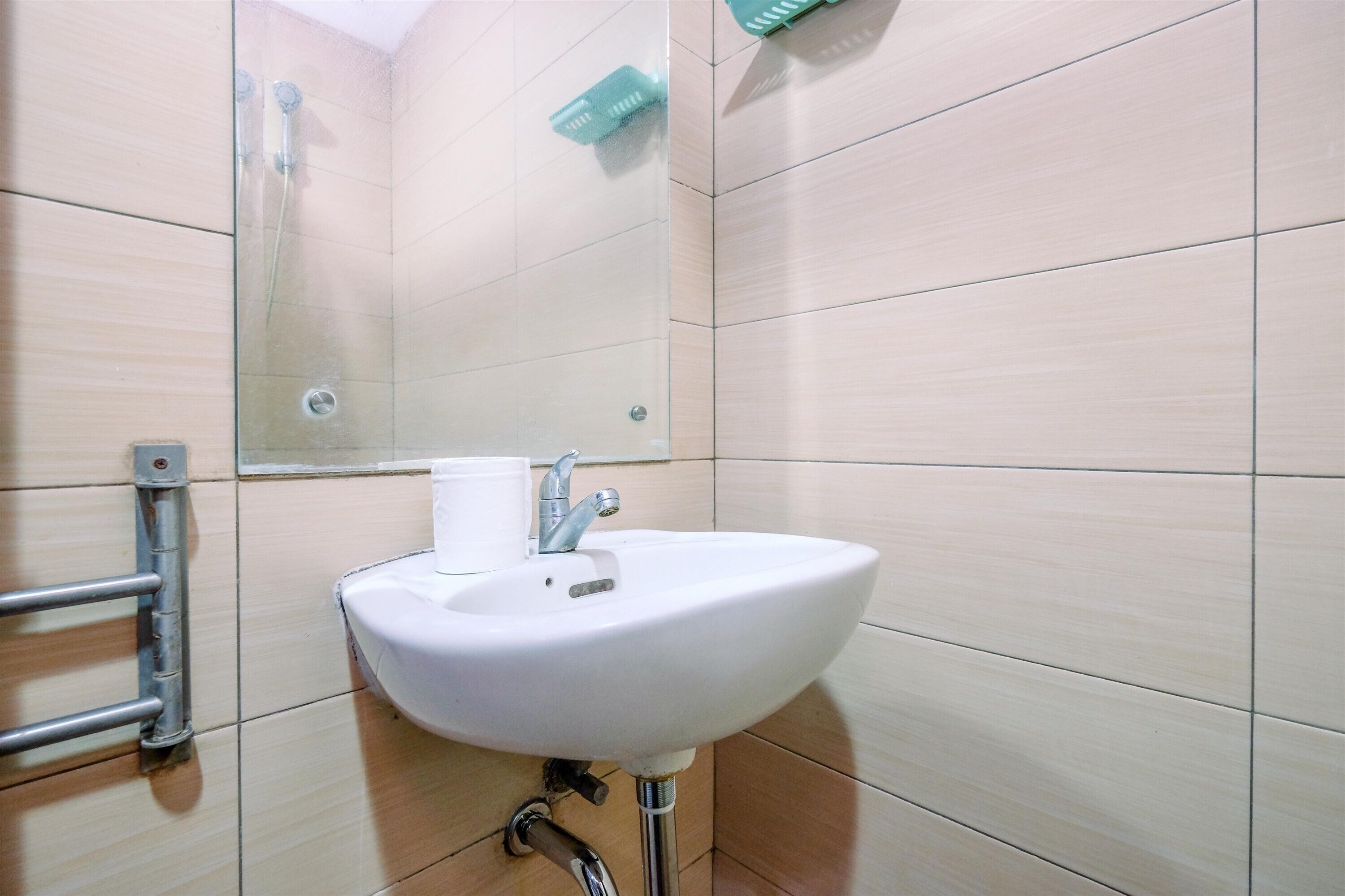Un baño con lavamanos blanco, espejo y ducha.