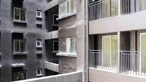Un edificio de varios pisos con balcones, ventanas amplias y fachada de concreto.