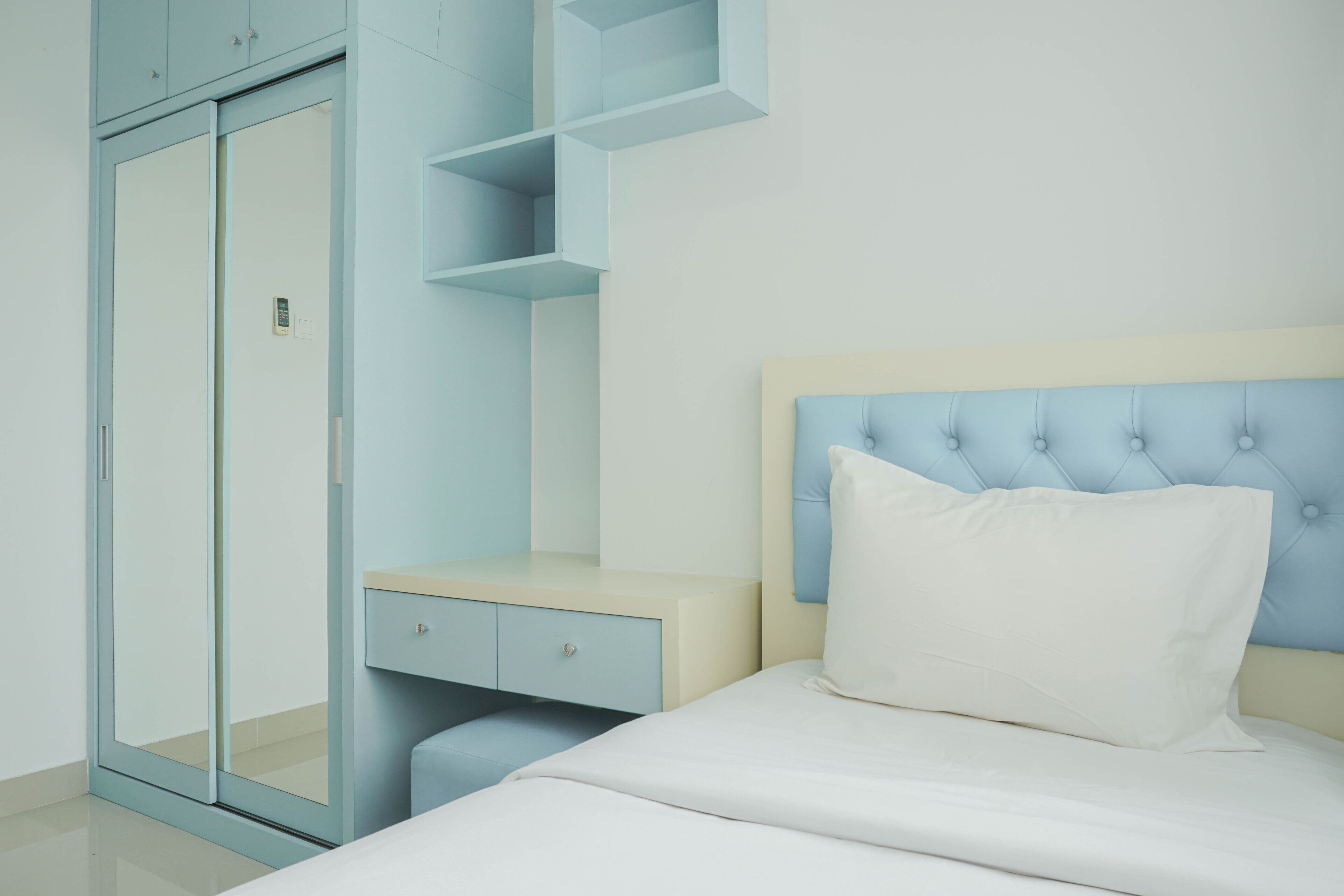Une chambre à coucher comprenant un lit, une table de chevet, une commode et une armoire.