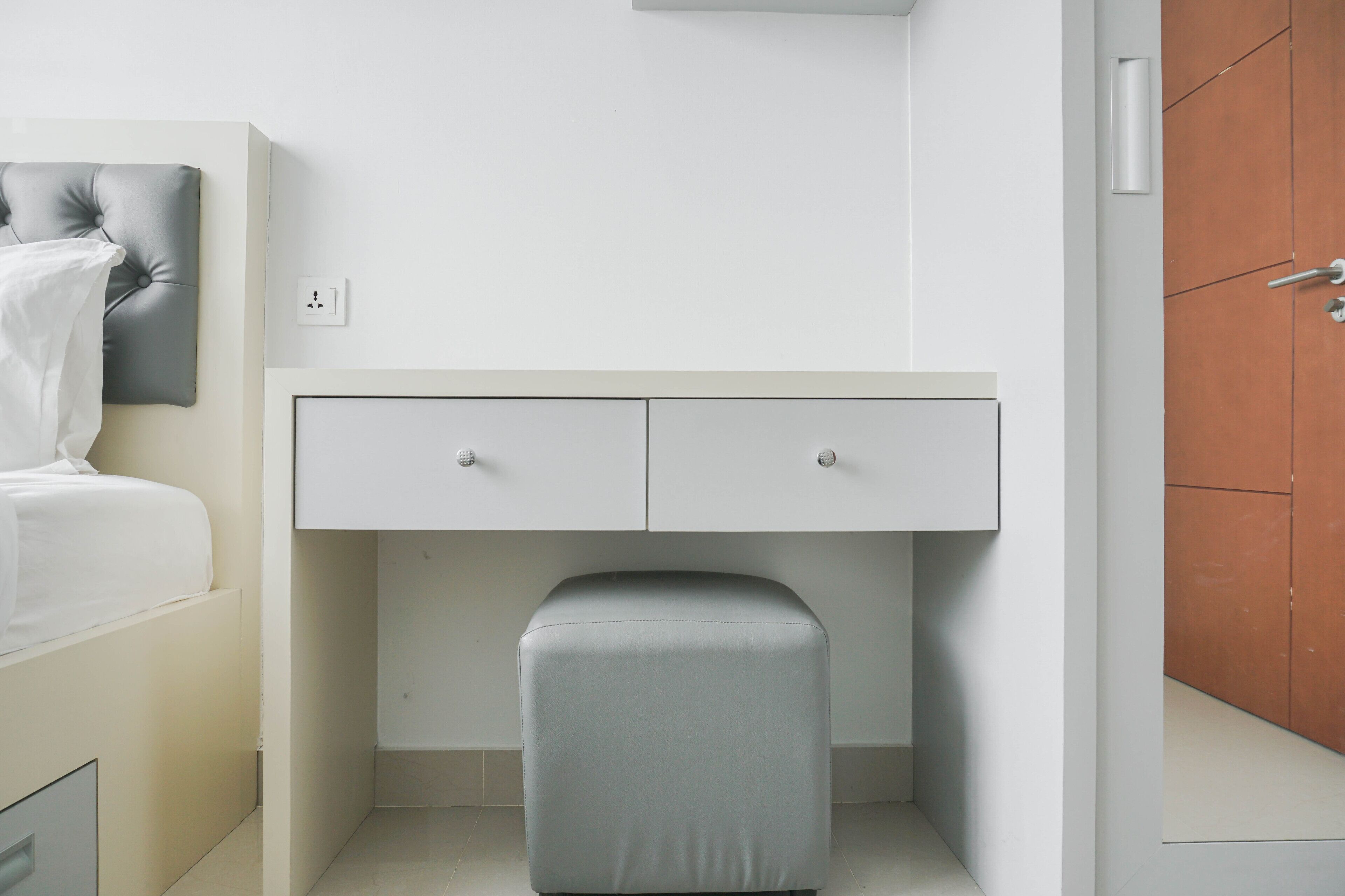 Une chambre à coucher moderne, avec un lit, un bureau et une armoire.
