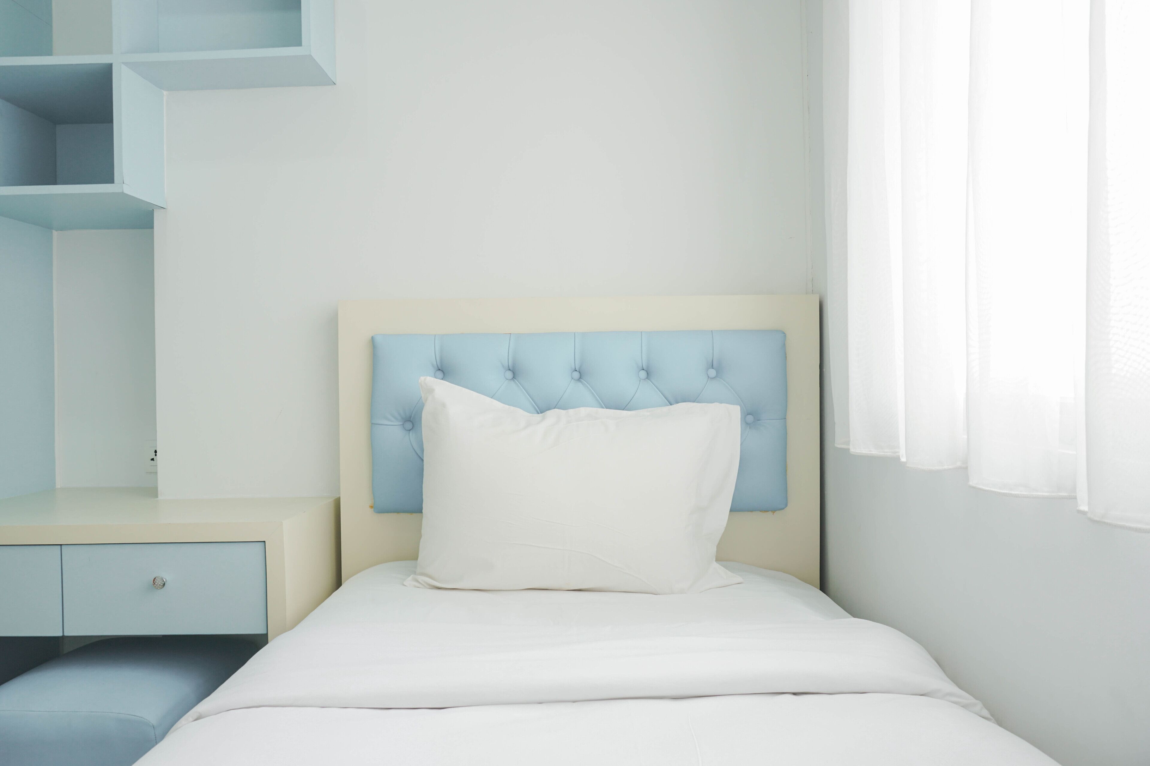 Ein Schlafzimmer mit einem Bett, einem Nachttisch und einer eingebauten Regaleinheit.