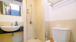 A bathroom with a sink, toilet, shower, and a towel on the toilet. - Best Deal Studio Apartment At Mangga Dua Residence (Jakarta)