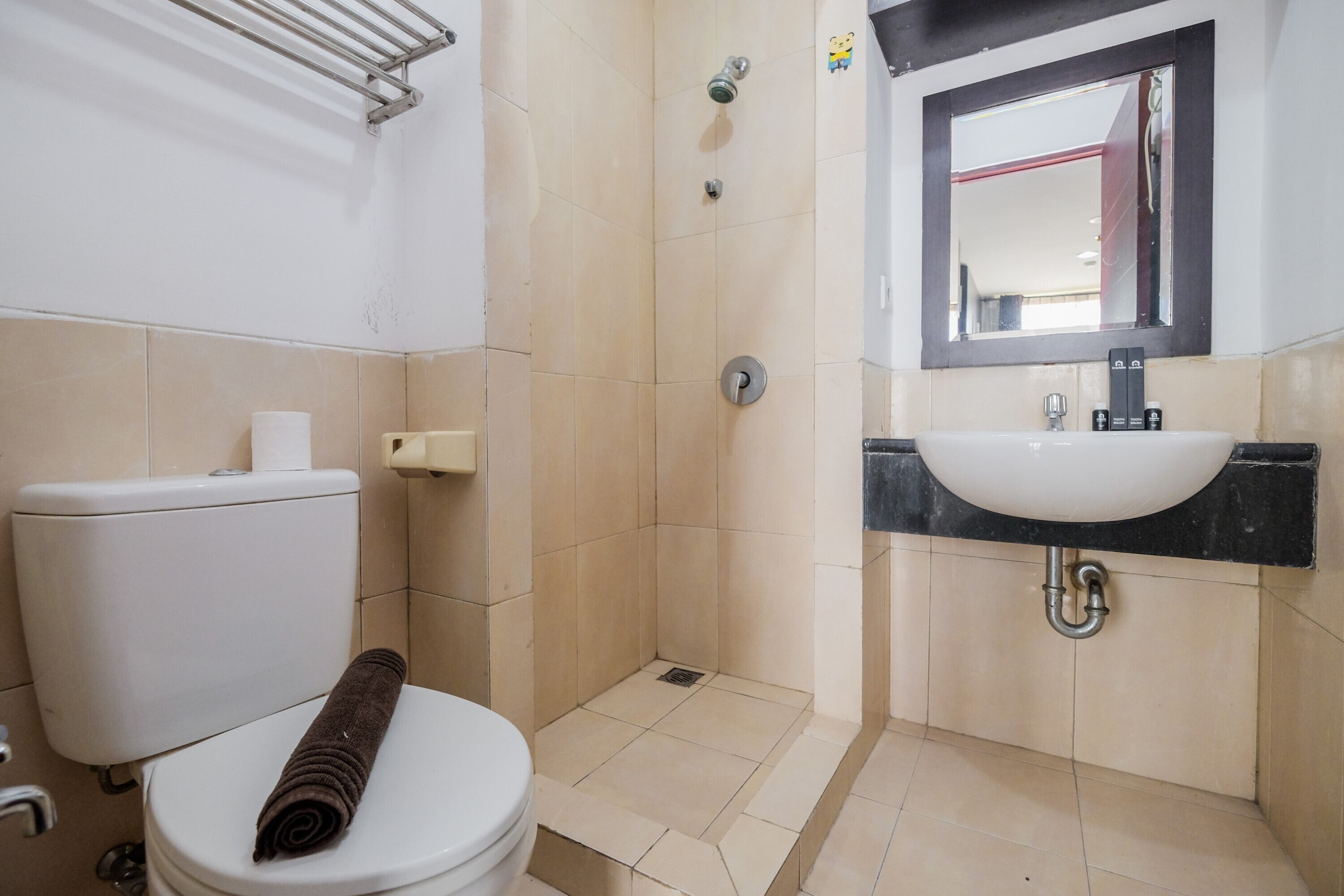 A bathroom with a toilet, a shower, and a sink.