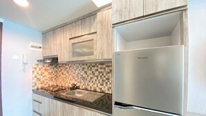 Une cuisine moderne avec des meubles en bois, un réfrigérateur en acier inoxydable et un dosseret à carreaux.