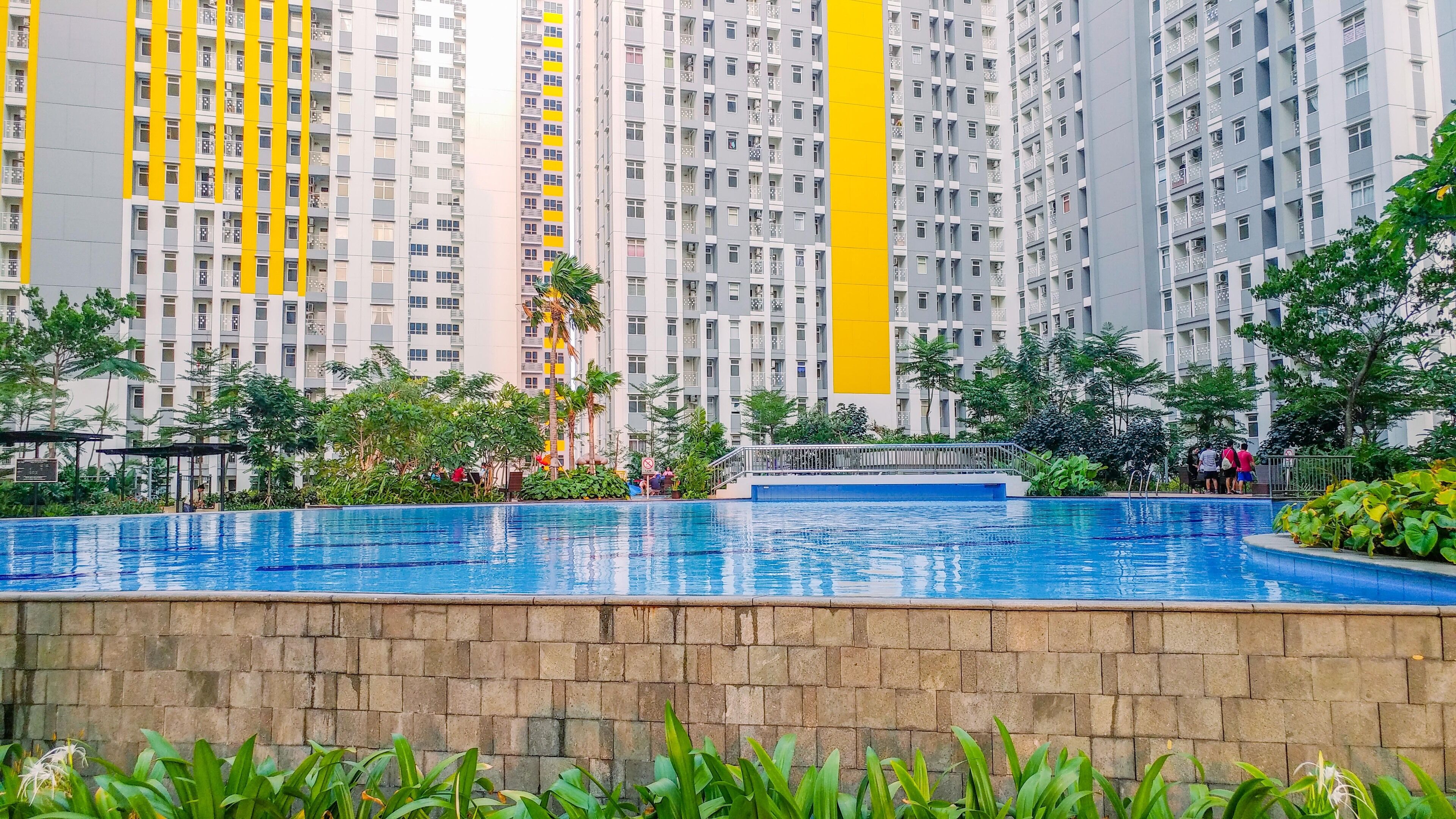 Un immeuble résidentiel doté de nombreux balcons et d’une piscine.