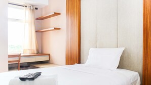 Une chambre d’hôtel avec un lit, un bureau et une chaise.