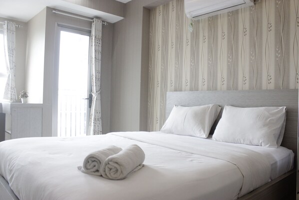 Relax in comfort with a large bed, neatly made with crisp linens, and enjoy the view from the window.