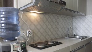 A kitchen with a water dispenser, a stove, and a sink.
