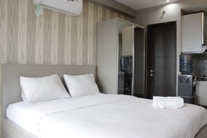 Relax in a spacious room with a large bed, wardrobe, and kitchenette.
